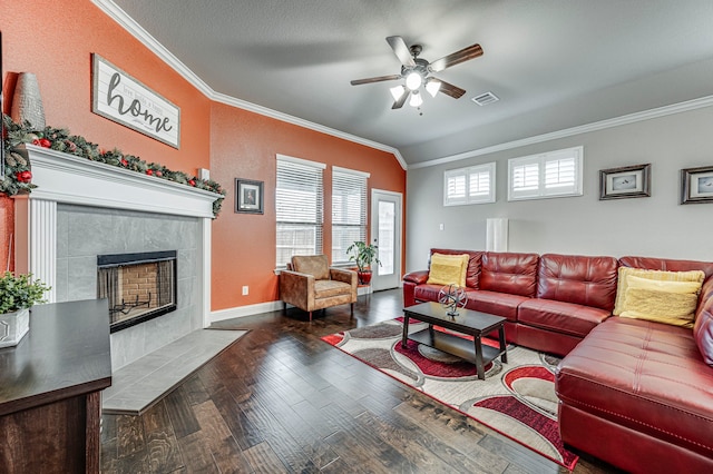 living room with lofted ceiling, ceiling fan, dark hardwood / wood-style floors, a tile fireplace, and ornamental molding