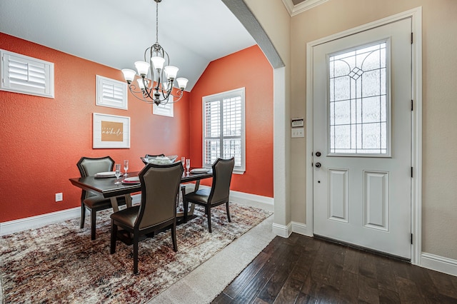 dining space featuring vaulted ceiling, an inviting chandelier, and dark hardwood / wood-style floors