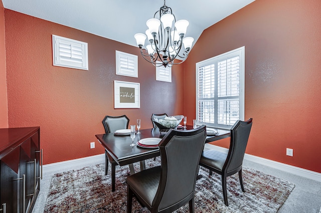 carpeted dining area with a chandelier and vaulted ceiling