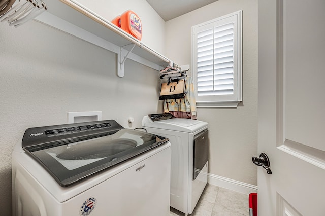 laundry area featuring light tile patterned floors and washing machine and clothes dryer