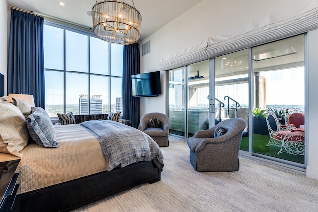 carpeted bedroom with multiple windows, a wall of windows, access to outside, and a notable chandelier