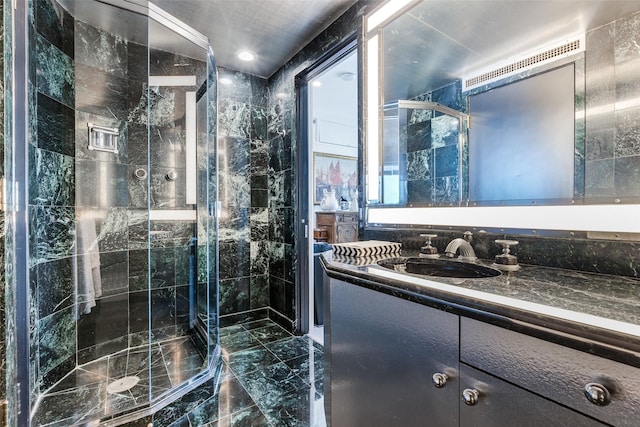 bathroom featuring a shower with shower door and vanity