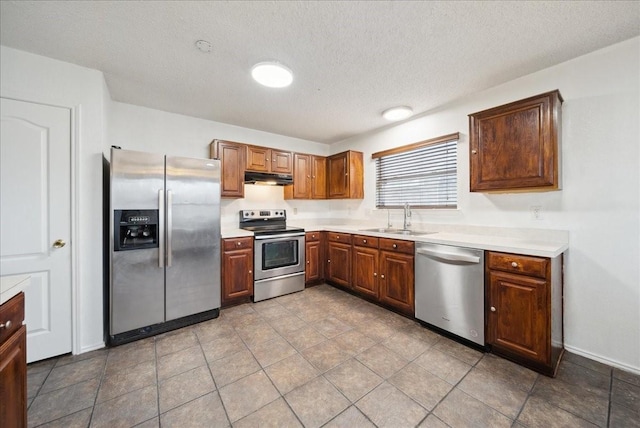 kitchen with sink, a textured ceiling, and appliances with stainless steel finishes