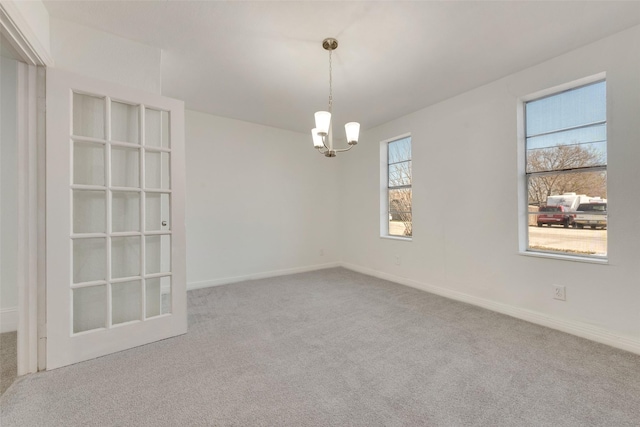 empty room with carpet floors and a chandelier