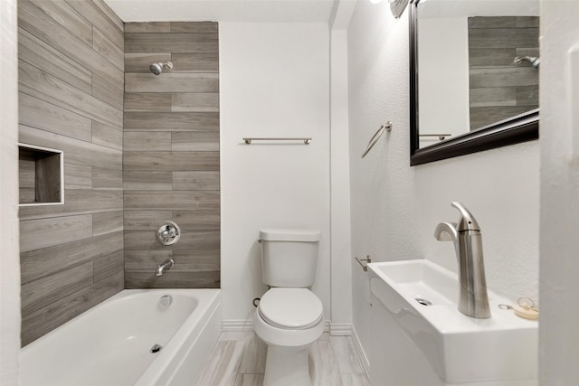 bathroom featuring toilet and tiled shower / bath