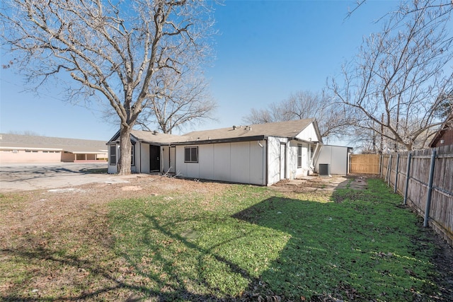 rear view of property with a lawn and central air condition unit