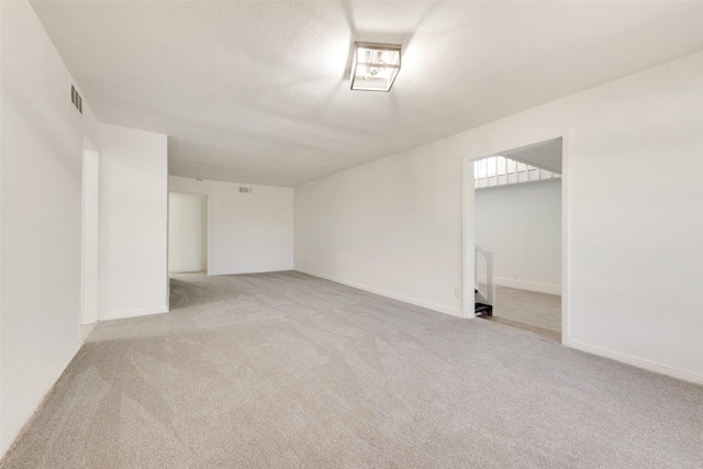 carpeted spare room featuring a textured ceiling