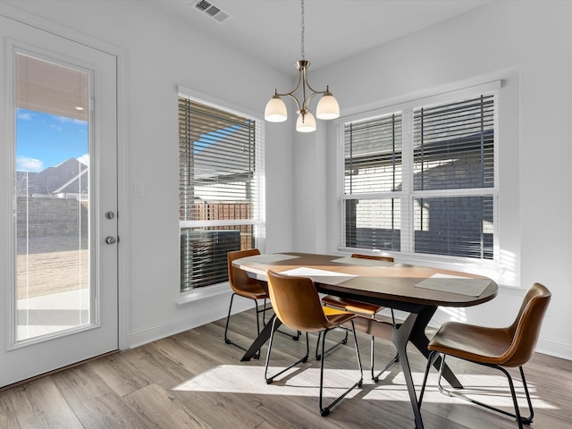 dining area featuring light hardwood / wood-style floors and a chandelier