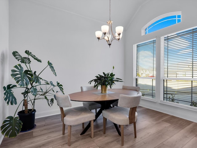 dining area featuring hardwood / wood-style flooring, an inviting chandelier, and lofted ceiling