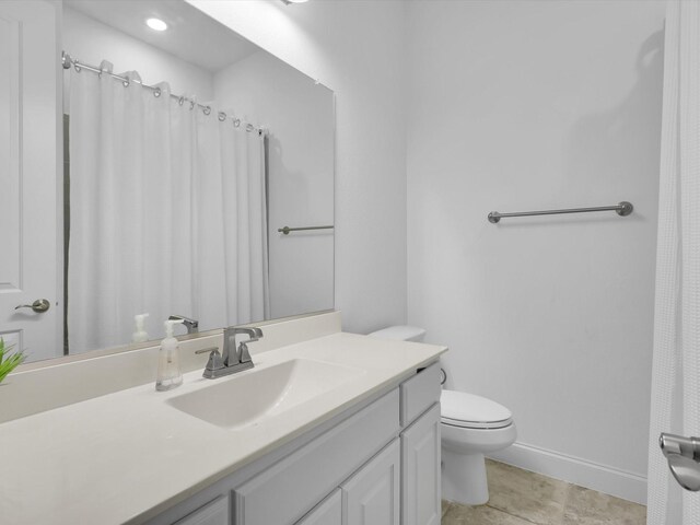 bathroom featuring vanity, toilet, and tile patterned flooring