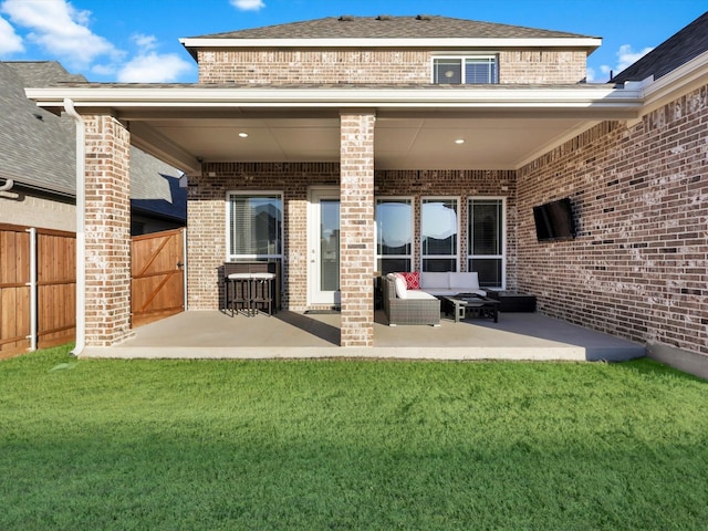 back of house featuring an outdoor living space, a lawn, and a patio