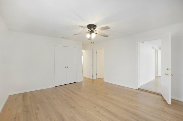 empty room with ceiling fan and light hardwood / wood-style floors