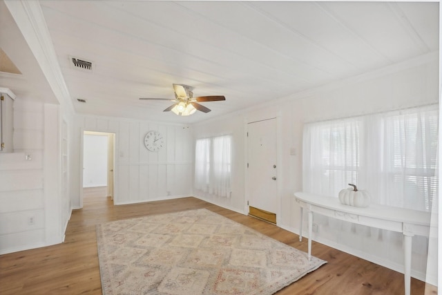 interior space with ceiling fan, ornamental molding, a healthy amount of sunlight, and hardwood / wood-style flooring