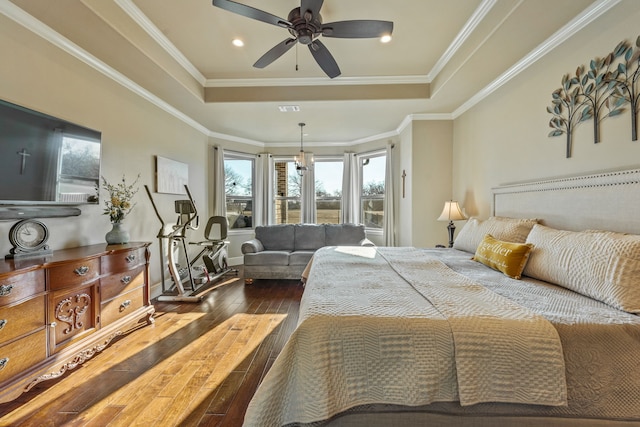 bedroom featuring ceiling fan, hardwood / wood-style floors, crown molding, and a raised ceiling