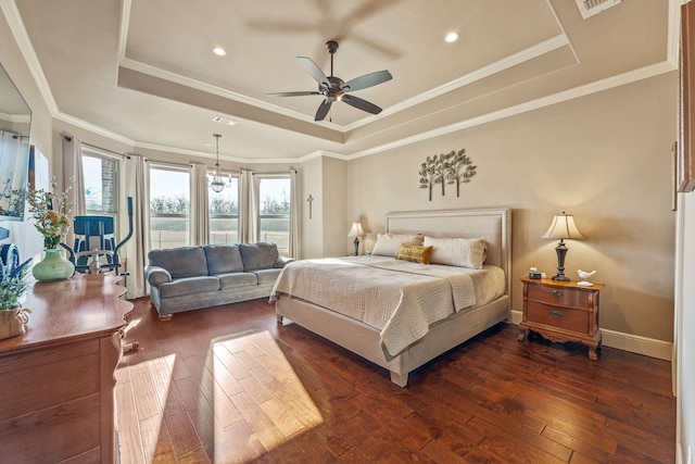 bedroom with ceiling fan, dark wood-type flooring, and a tray ceiling