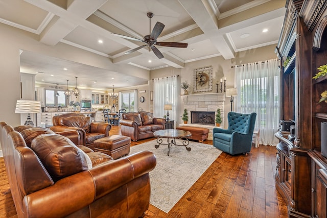 living room with dark hardwood / wood-style flooring, a stone fireplace, beamed ceiling, and coffered ceiling