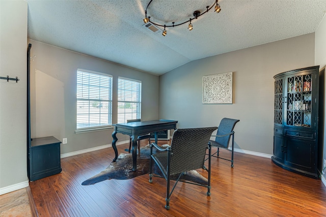 dining room with lofted ceiling, a textured ceiling, and hardwood / wood-style flooring