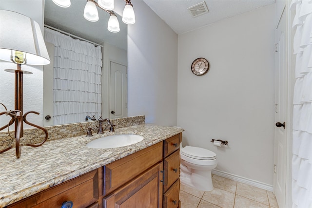 bathroom featuring a textured ceiling, toilet, vanity, and tile patterned flooring