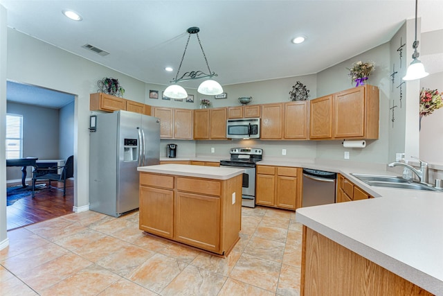 kitchen featuring a kitchen island, pendant lighting, light tile patterned flooring, sink, and stainless steel appliances