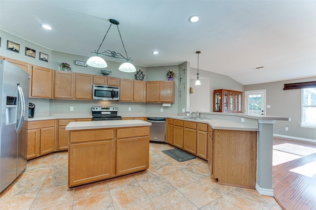 kitchen with pendant lighting, a center island, stainless steel appliances, sink, and kitchen peninsula