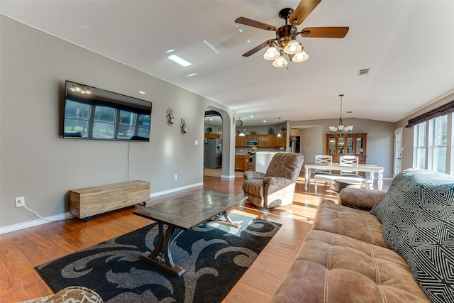 living room featuring hardwood / wood-style flooring, ceiling fan, and vaulted ceiling