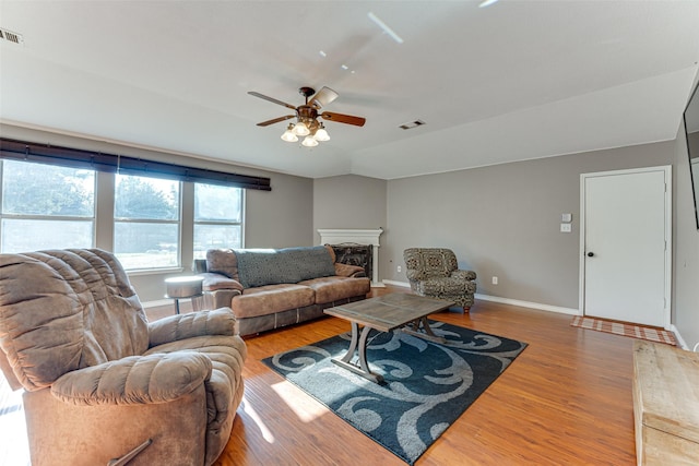 living room with ceiling fan, hardwood / wood-style floors, and vaulted ceiling