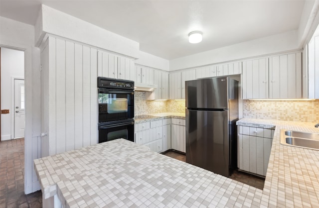 kitchen featuring backsplash, white cabinets, sink, and black appliances