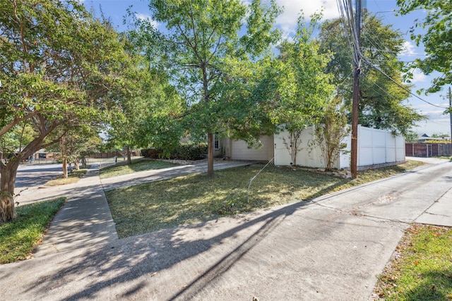 view of property hidden behind natural elements featuring a front yard