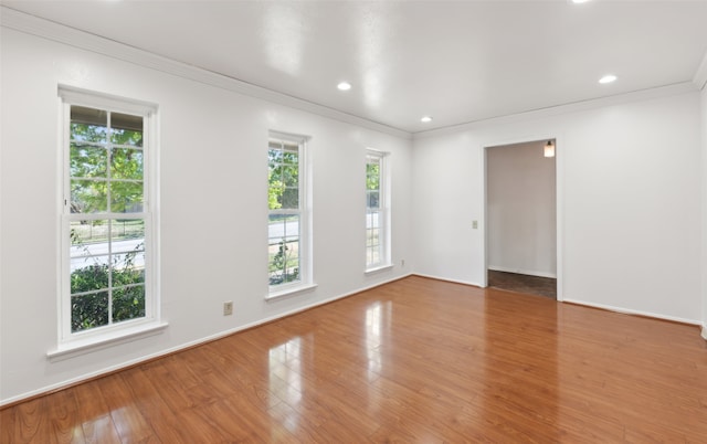 spare room with crown molding and wood-type flooring