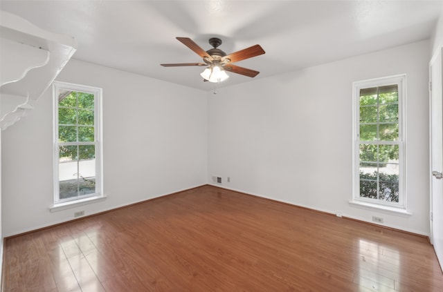 unfurnished room with ceiling fan, a healthy amount of sunlight, and hardwood / wood-style floors