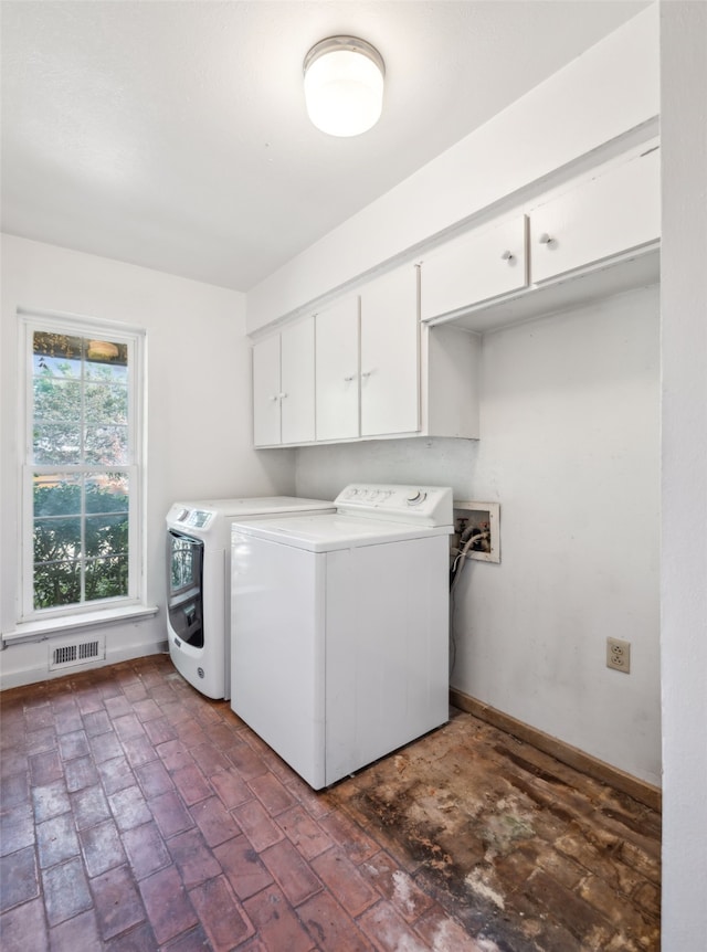 washroom featuring washer and clothes dryer and cabinets