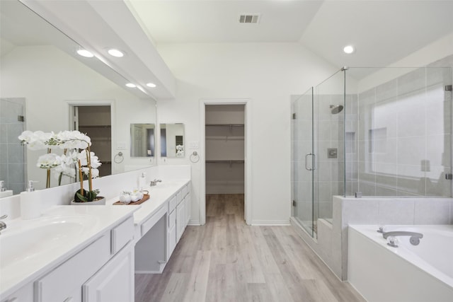 bathroom featuring vanity, lofted ceiling, hardwood / wood-style floors, and separate shower and tub