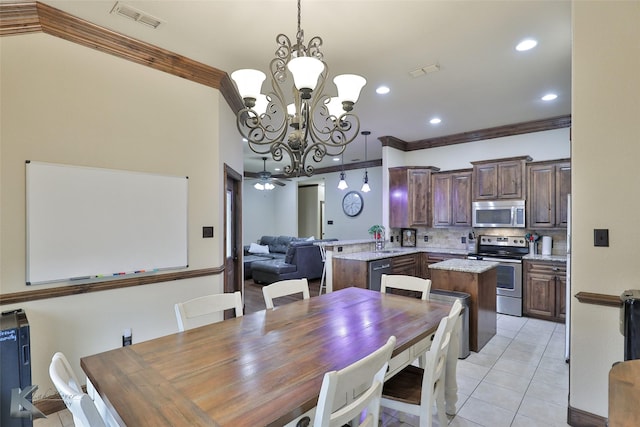 tiled dining area featuring ornamental molding and a chandelier