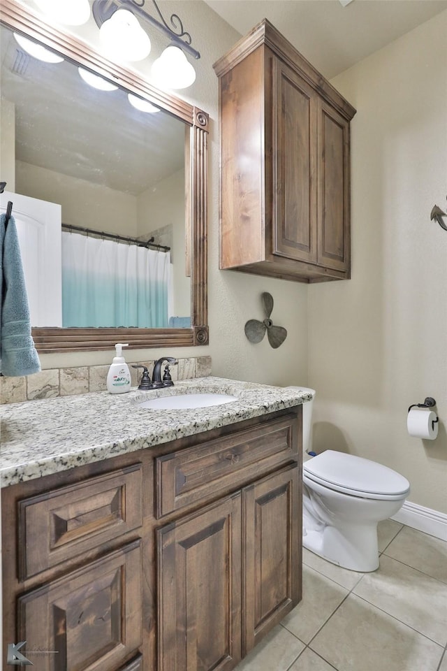 bathroom featuring tile patterned floors, vanity, and toilet