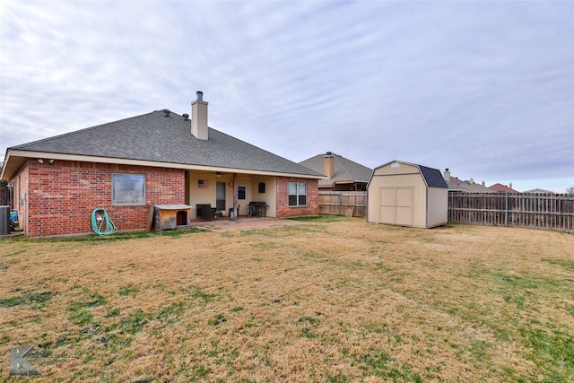 back of property with central air condition unit, a yard, and a storage unit