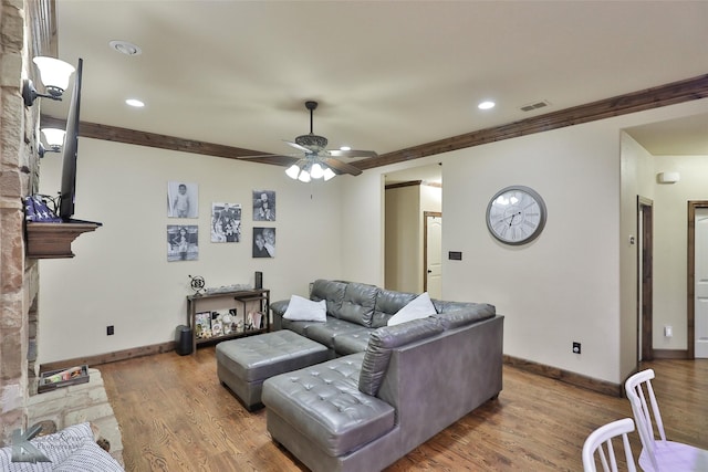 living room featuring hardwood / wood-style flooring, ornamental molding, and ceiling fan