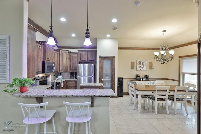 kitchen featuring stainless steel appliances, a kitchen breakfast bar, hanging light fixtures, kitchen peninsula, and crown molding