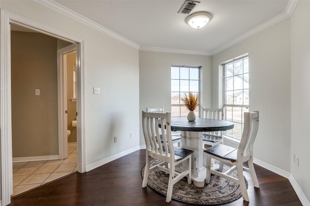 dining room with dark hardwood / wood-style flooring and crown molding