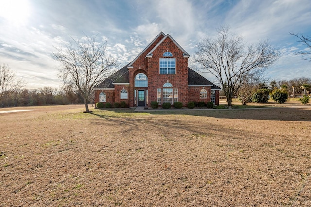 traditional home featuring brick siding and a front yard