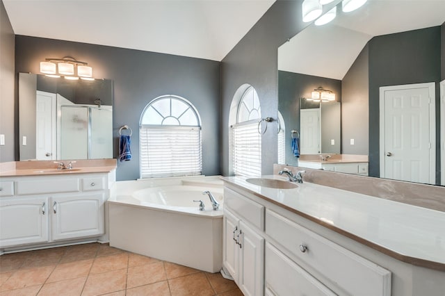 bathroom featuring tile patterned flooring, vanity, vaulted ceiling, and separate shower and tub