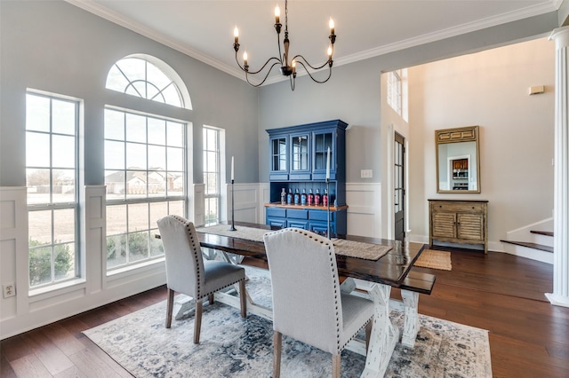 dining area featuring dark hardwood / wood-style flooring, crown molding, and a chandelier