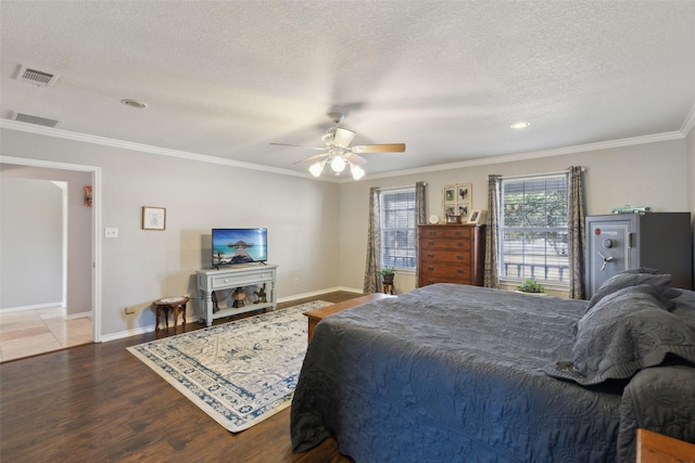 bedroom featuring ceiling fan, wood-type flooring, crown molding, and a textured ceiling