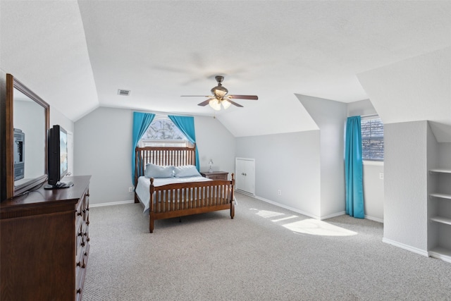 carpeted bedroom with multiple windows, vaulted ceiling, and ceiling fan