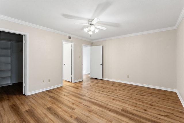 unfurnished bedroom with ceiling fan, light hardwood / wood-style floors, crown molding, a spacious closet, and a closet