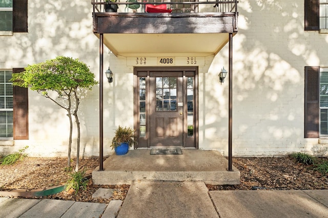 view of exterior entry with a balcony