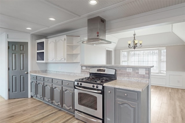 kitchen with gray cabinets, gas stove, light hardwood / wood-style floors, white cabinets, and island range hood