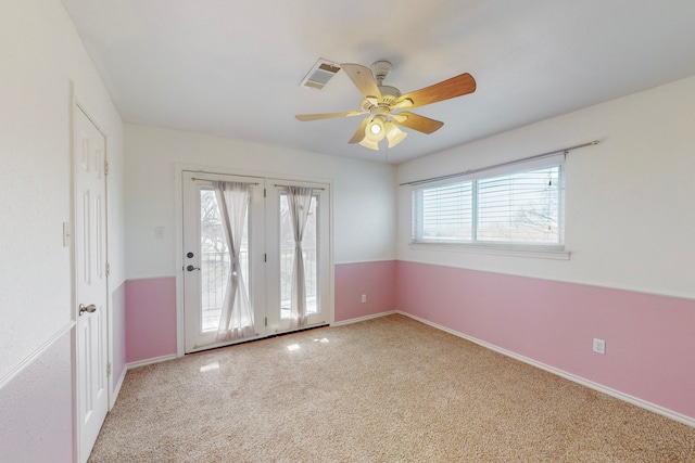 carpeted empty room featuring ceiling fan and a healthy amount of sunlight