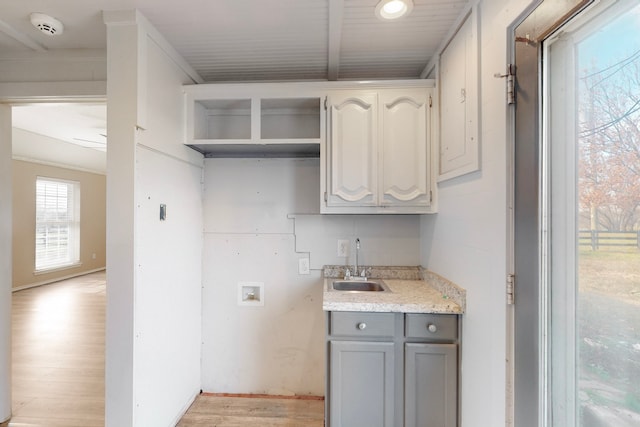 laundry room with light wood-type flooring, hookup for a washing machine, and sink