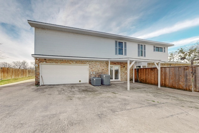 view of front of house with a garage and central air condition unit