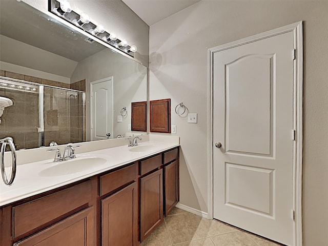 bathroom with a shower with shower door, vanity, tile patterned flooring, and vaulted ceiling